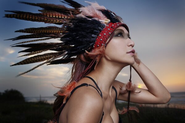 A girl with feathers on the background of nature