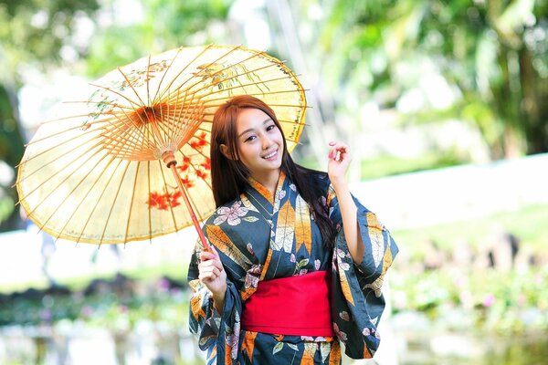 Mädchen im asiatischen Stil mit einem Regenschirm an ihren Händen , elegant