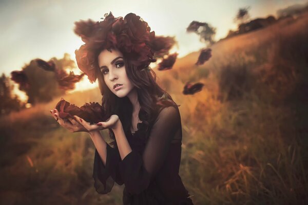 A girl with a broom made of autumn leaves