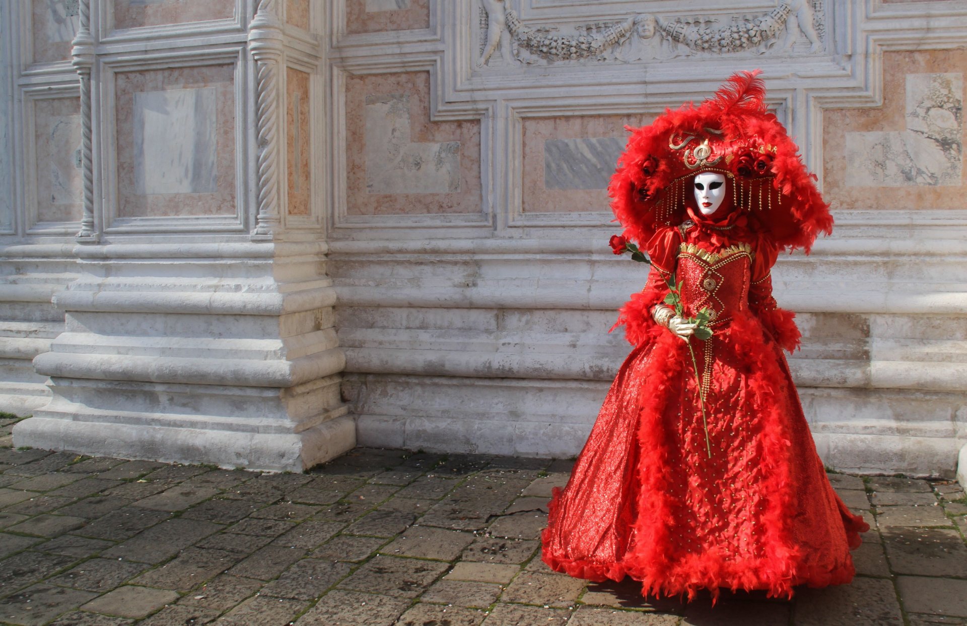 fille robe de carnaval rouge masque chapeau fleur rose mur