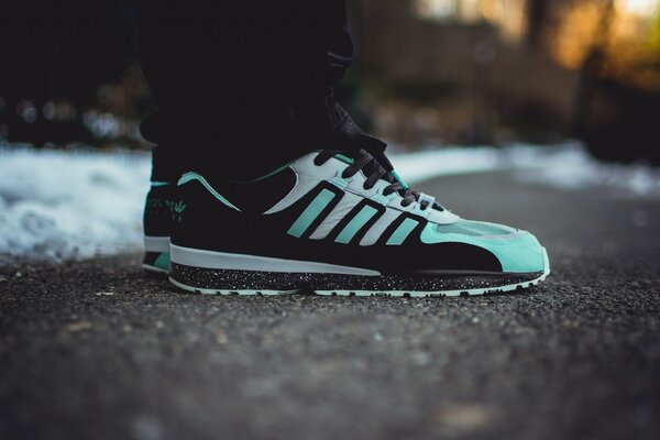 Turquoise adidas sneakers on the feet