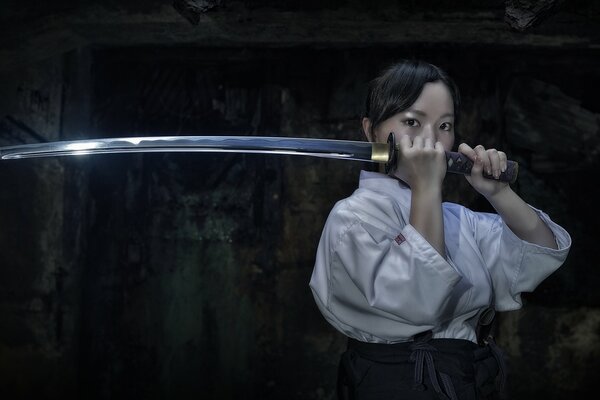 Fille asiatique avec katana épée dans les mains