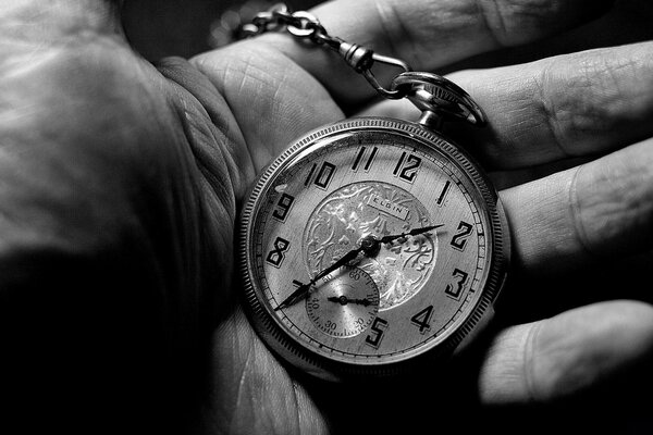 Schwarz-Weiß-Foto einer Armbanduhr in der Handfläche