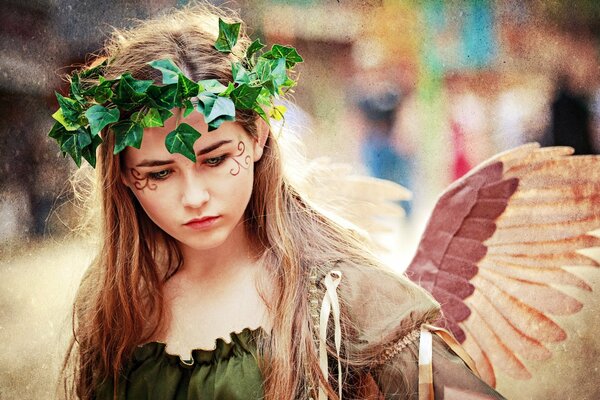 A girl with wings and a green wreath