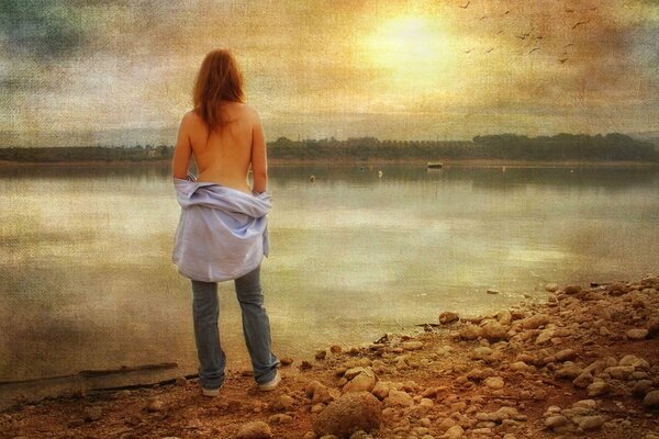 A girl with a half-removed shirt near regi against the background of the evening sky
