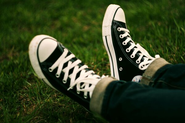 Image de pieds en baskets sur l herbe