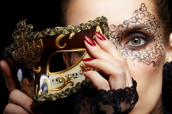 Carnival golden mask. Red manicure