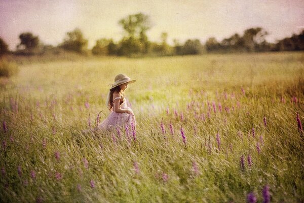 A girl in a hat in a summer field