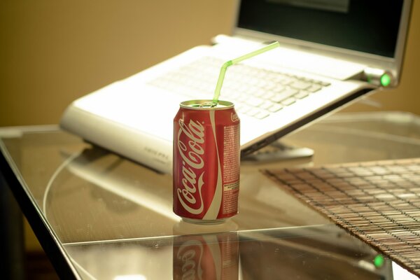 Coca Cola on the background of a laptop