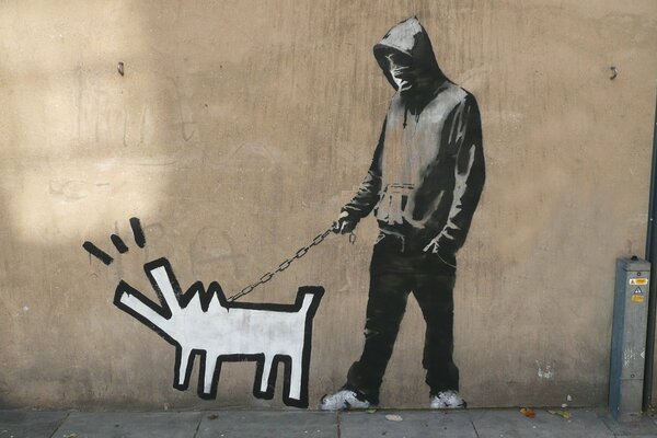 Chico camina con el perro de Banksy y ella ladra