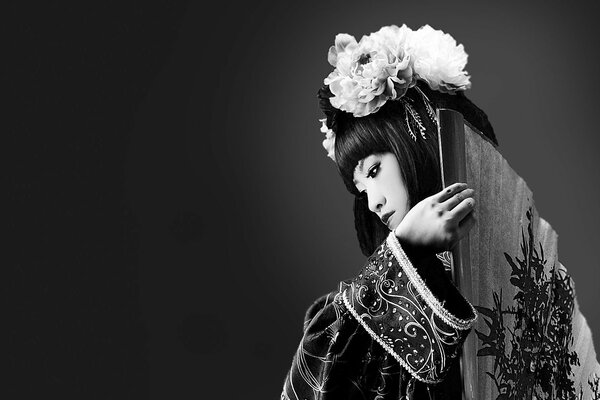 Black and white photo of a Japanese girl with a fan behind her back