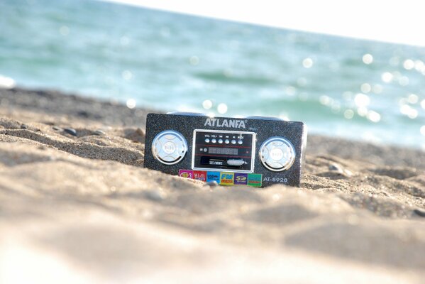 Radio en la arena en la orilla del mar