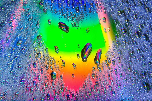 Rainbow heart on glass with drops