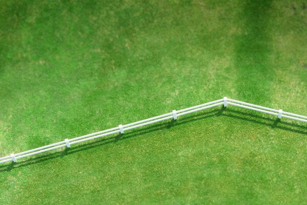 Top view of a lawn with a white fence