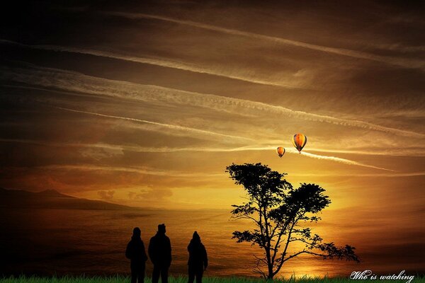 Menschen schauen auf fliegende Ballons in den Himmel