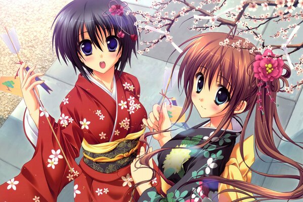 Two girls in bright kimonos next to sakura