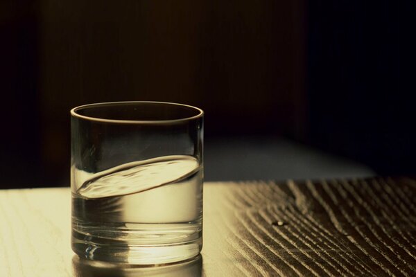 Ein Glas Wasser auf einem Holztisch