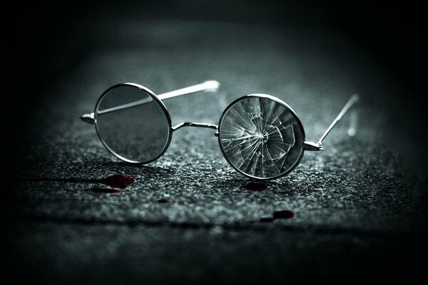 Broken round glasses on the asphalt