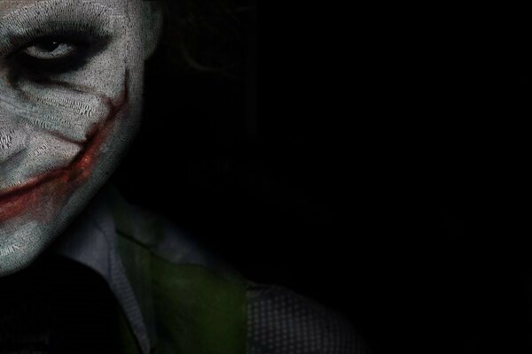 The Joker smiles maliciously on a black background