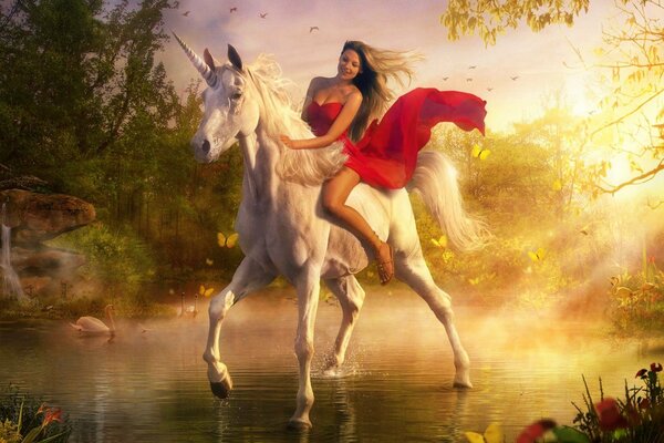 Hermosa jinete en un vestido rojo montando un unicornio blanco como la nieve en la tierra de la fantasía