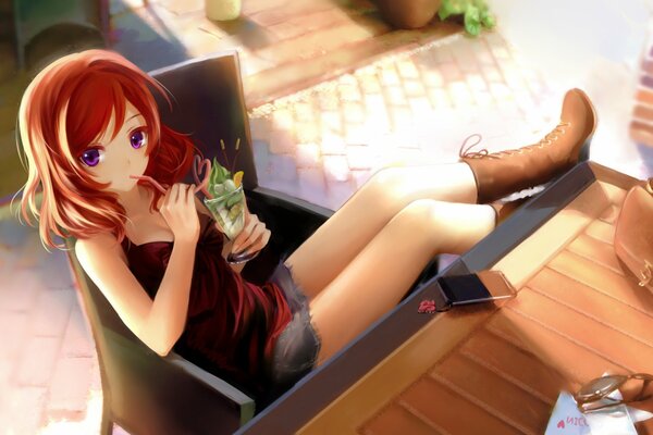 Das Mädchen sitzt am Tisch und trinkt einen Cocktail durch ein Anime-Röhrchen
