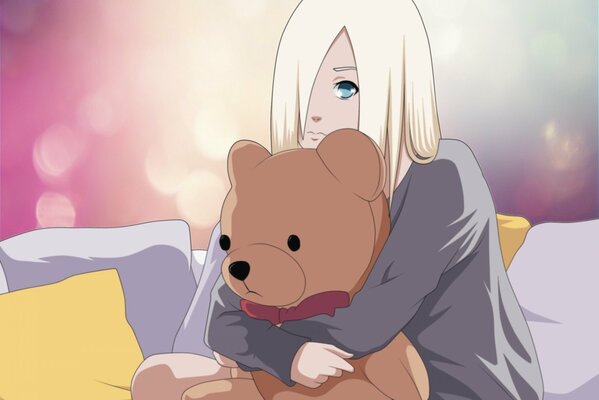 Blonde girl hugs a teddy bear