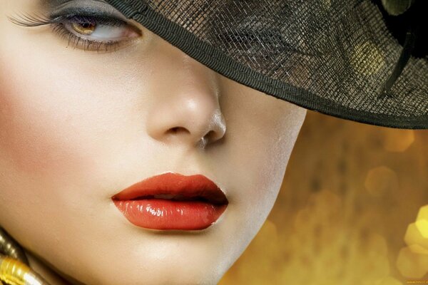 A girl in a hat with bright lipstick on her lips