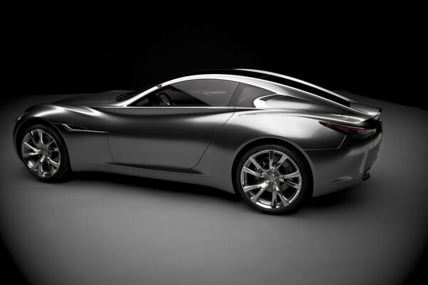 On a black background - a shiny silver concept car
