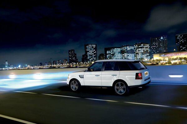 En el fondo de la ciudad nocturna Jeep blanco