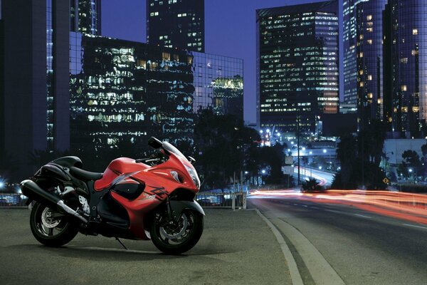 Motocicleta roja y negra en la ciudad nocturna en la carretera