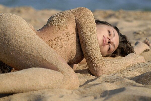 Nu inconscient découvert dans le sable