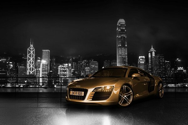 Audi en color dorado en el fondo de la ciudad nocturna