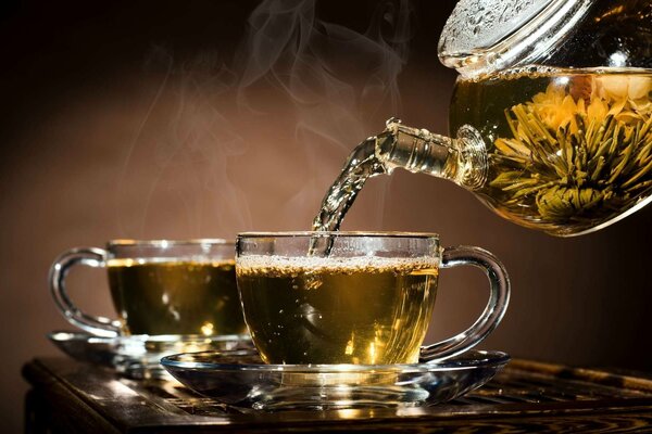 Tea from the teapot is poured into cups