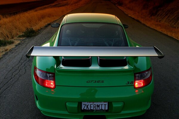 Porsche verde en la carretera de montaña