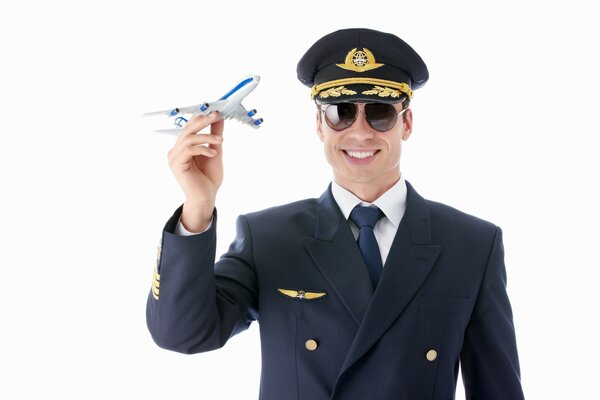 Pilote souriant avec un avion jouet dans les mains