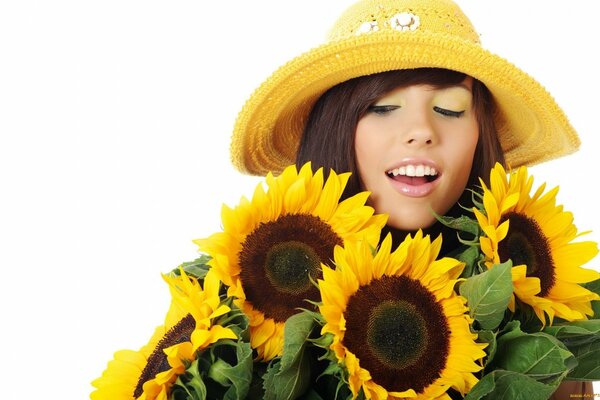 A beautiful face in a hat near sunflowers