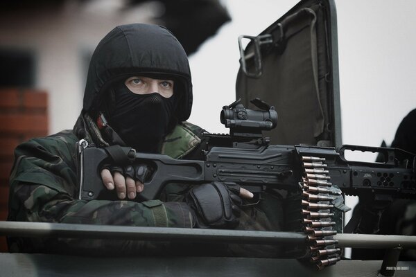 Maskiertes Militär mit Maschinengewehr Foto