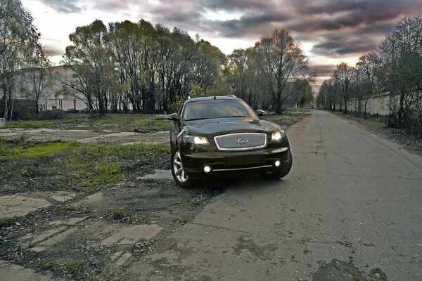 Infiniti fx35 sur la route sur fond d arbres