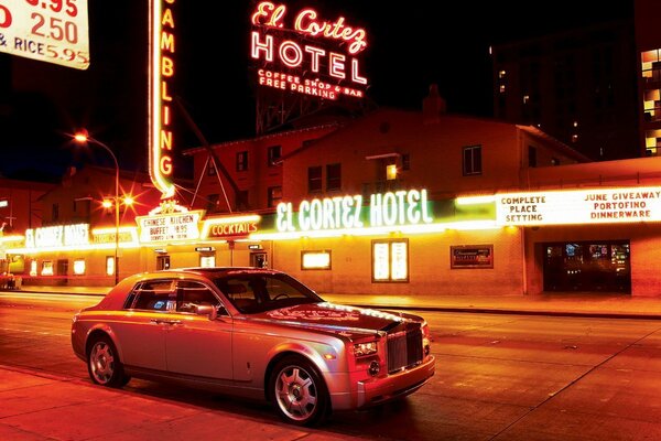 Rolls royce on the background of neon advertising and the night city