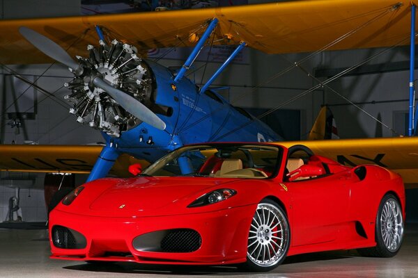 Ferari rojo en el hangar con el avión