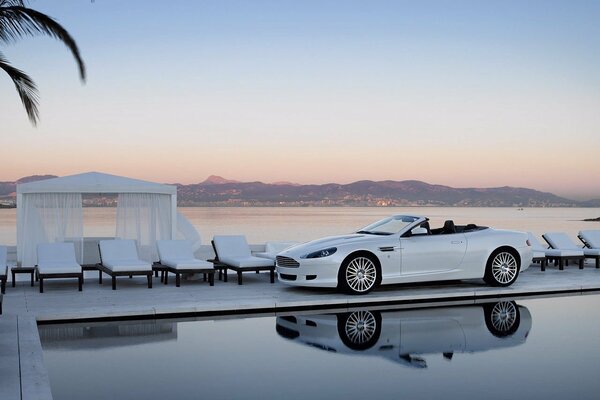 Near the pool, a white Bentley on the background of Shchaliv and the mountains