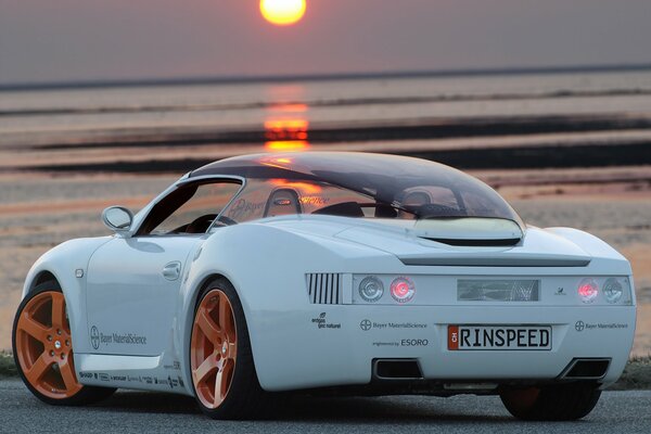 The car is on the seashore. Sunset