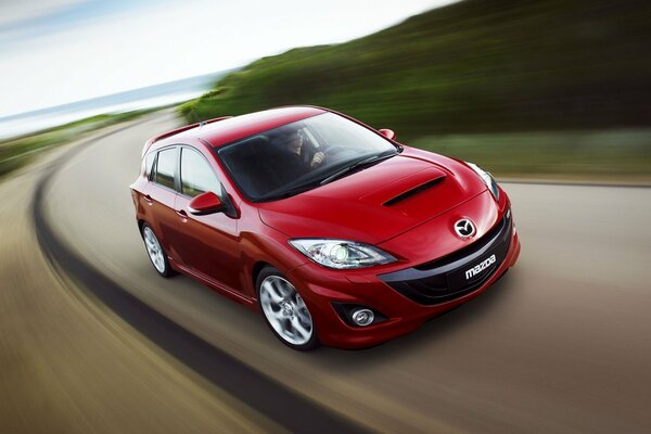 A beautiful red Mazda that rushes along the highway