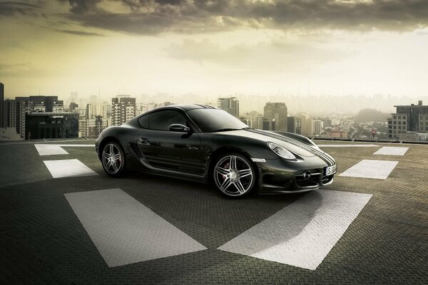 A Porsche parked on the roof of a multi-storey building