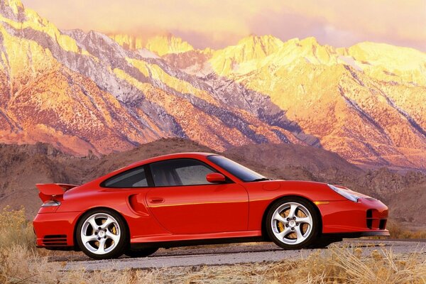 Red car in the mountains at sunset