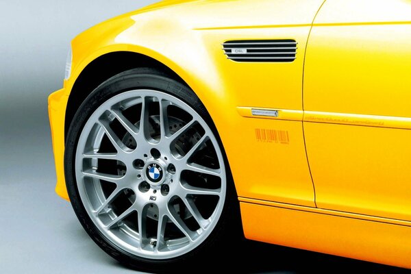 Zbliżenie przedniego koła żółtego BMW