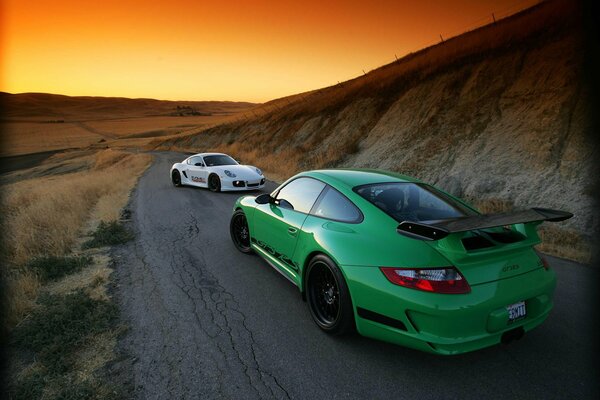 Voiture de sport porsche gt-3 sur fond de coucher de soleil