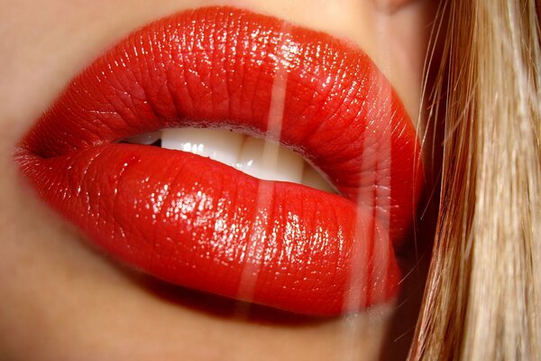 Lápiz labial rojo en los labios de la rubia primer plano