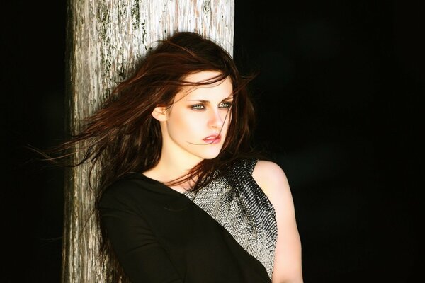 A girl in a black and gray dress on a black background