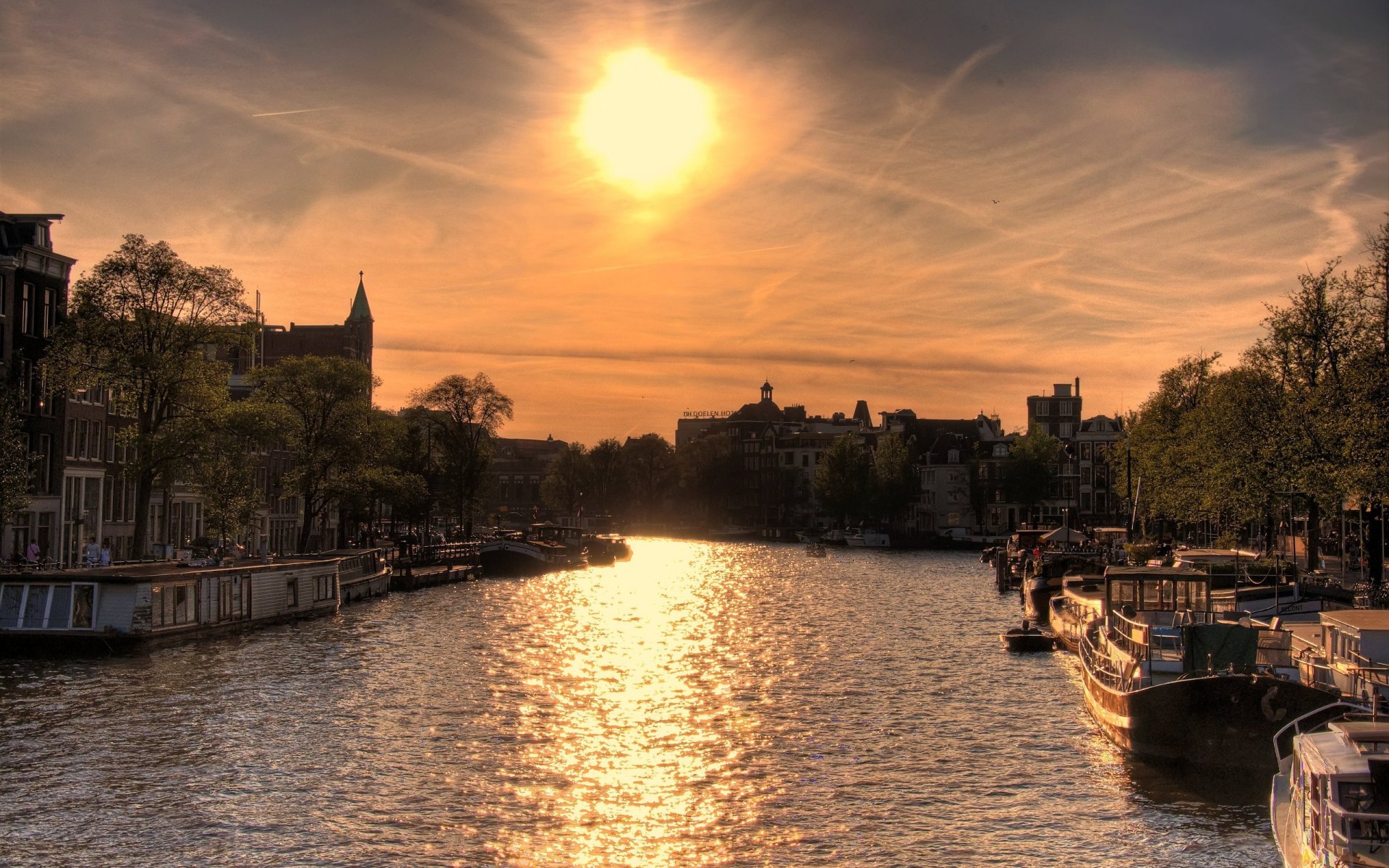 sole sopra amsterdam fiume sole barche case tramonto